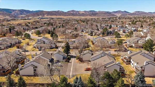 an aerial view of a house with a yard and mountain view in back