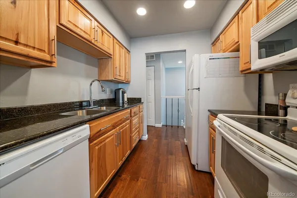 a kitchen with stainless steel appliances granite countertop a sink a stove and a refrigerator
