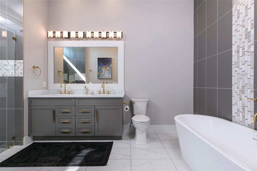 1514 Corolla Court Reunion, FL 34747 - Photo 17 of 74 a bathroom with a double vanity sink a toilet and a mirror