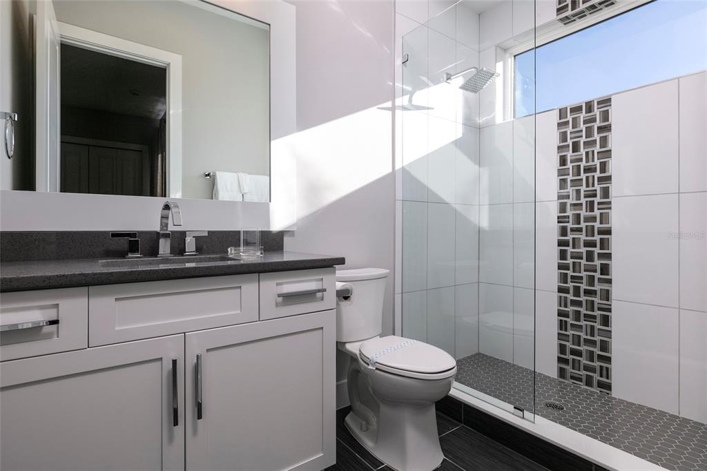 1514 Corolla Court Reunion, FL 34747 - Photo 21 of 74 a bathroom with a granite countertop sink a toilet and shower