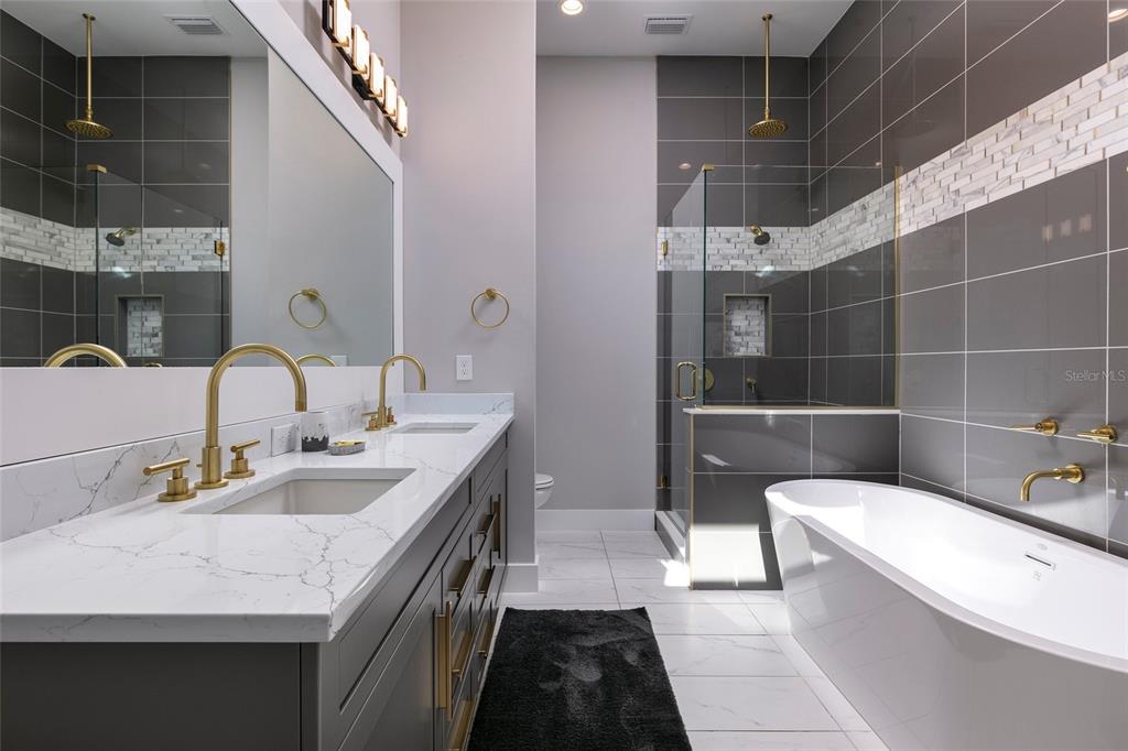 1514 Corolla Court Reunion, FL 34747 - Photo 42 of 74 a bathroom with a double vanity sink a toilet a mirror and shower