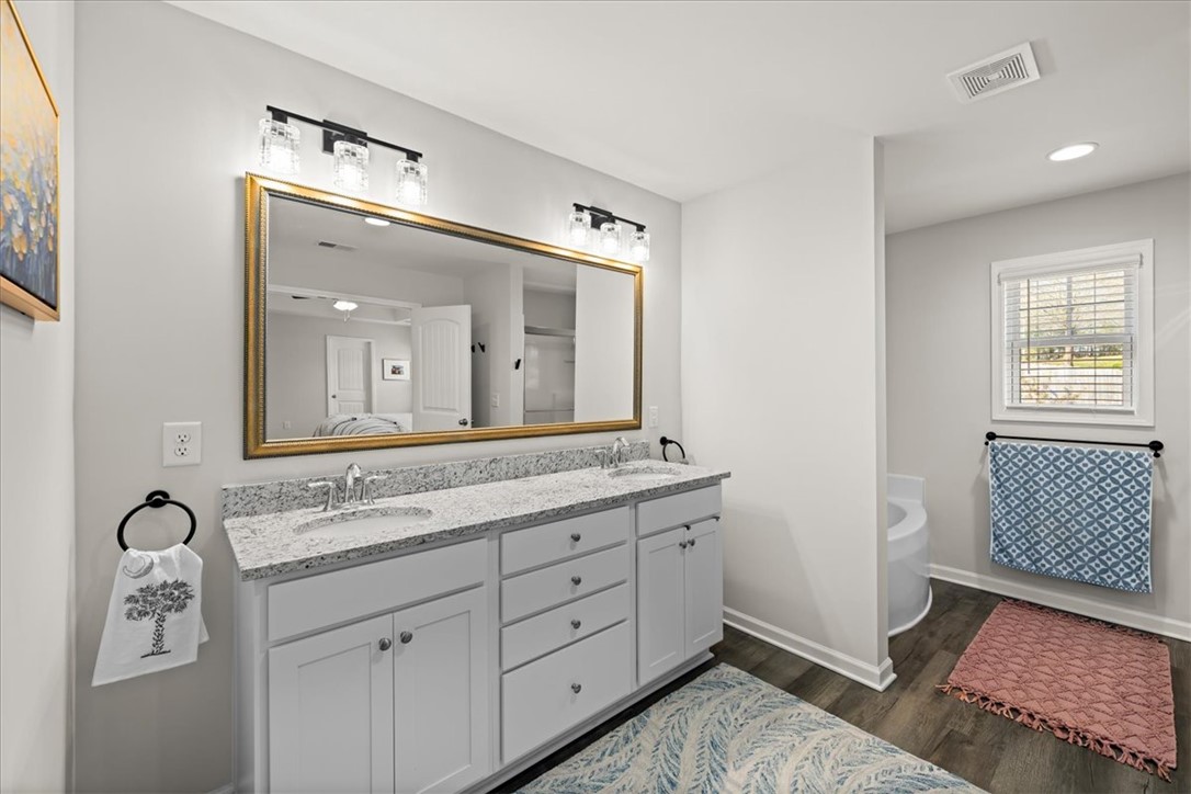 216 Carvel Trail Seneca, SC 29678 - Photo 29 of 48 This bathroom features a double vanity with granite counters and rich hardwood flooring.