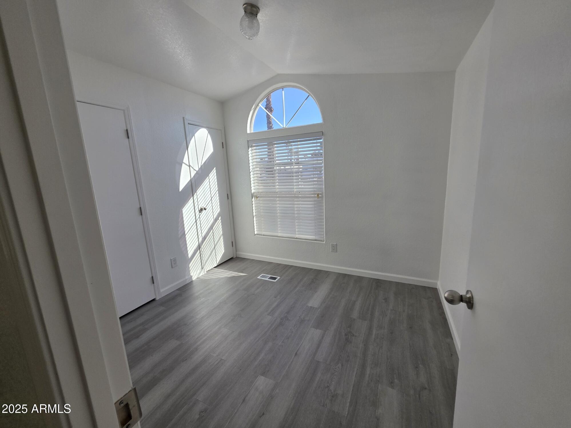 7807 East Main Street, Unit C6 Mesa, AZ 85207 - Photo 13 of 32 an empty room with wooden floor cabinet and a window