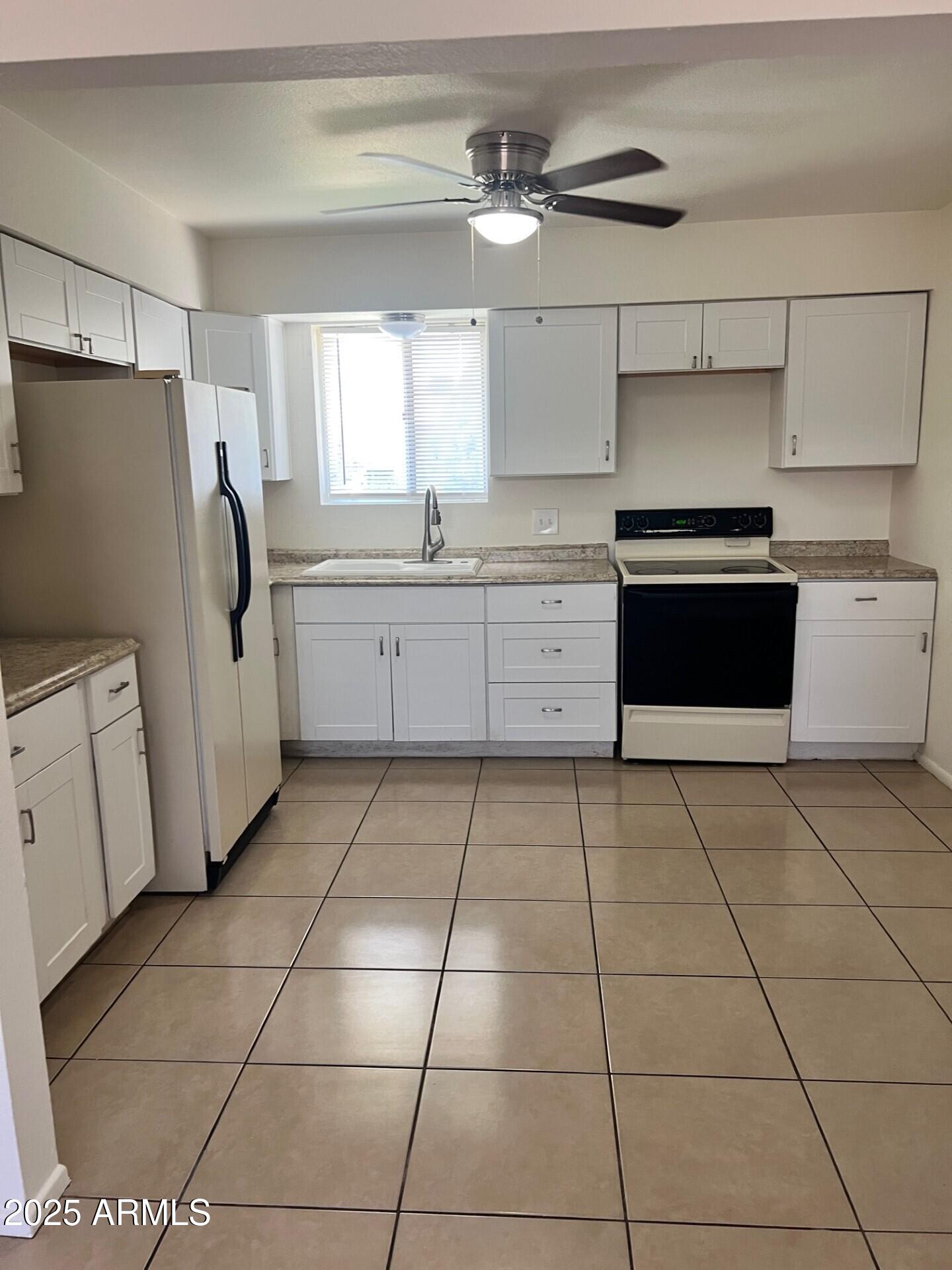 540 North Hall Mesa, AZ 85203 - Photo 8 of 9 a kitchen with a stove top oven cabinets and a refrigerator