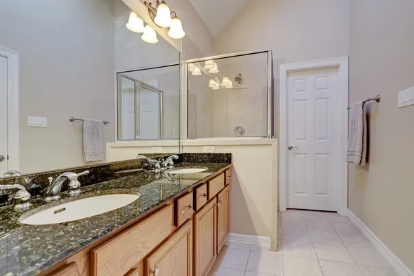 a bathroom with a granite countertop sink and a mirror