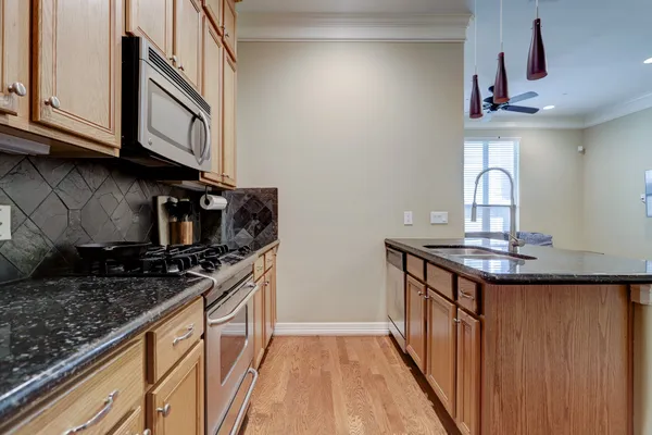 a kitchen with stainless steel appliances granite countertop a stove and a sink