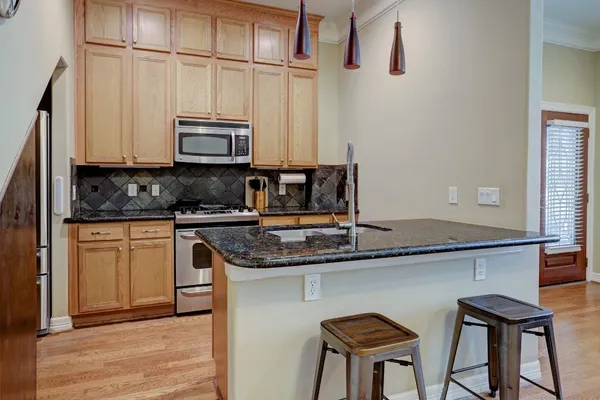 a kitchen with stainless steel appliances granite countertop a sink a stove and a microwave