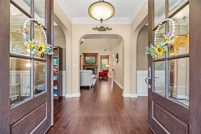 a view of a hallway with wooden floor and chandelier
