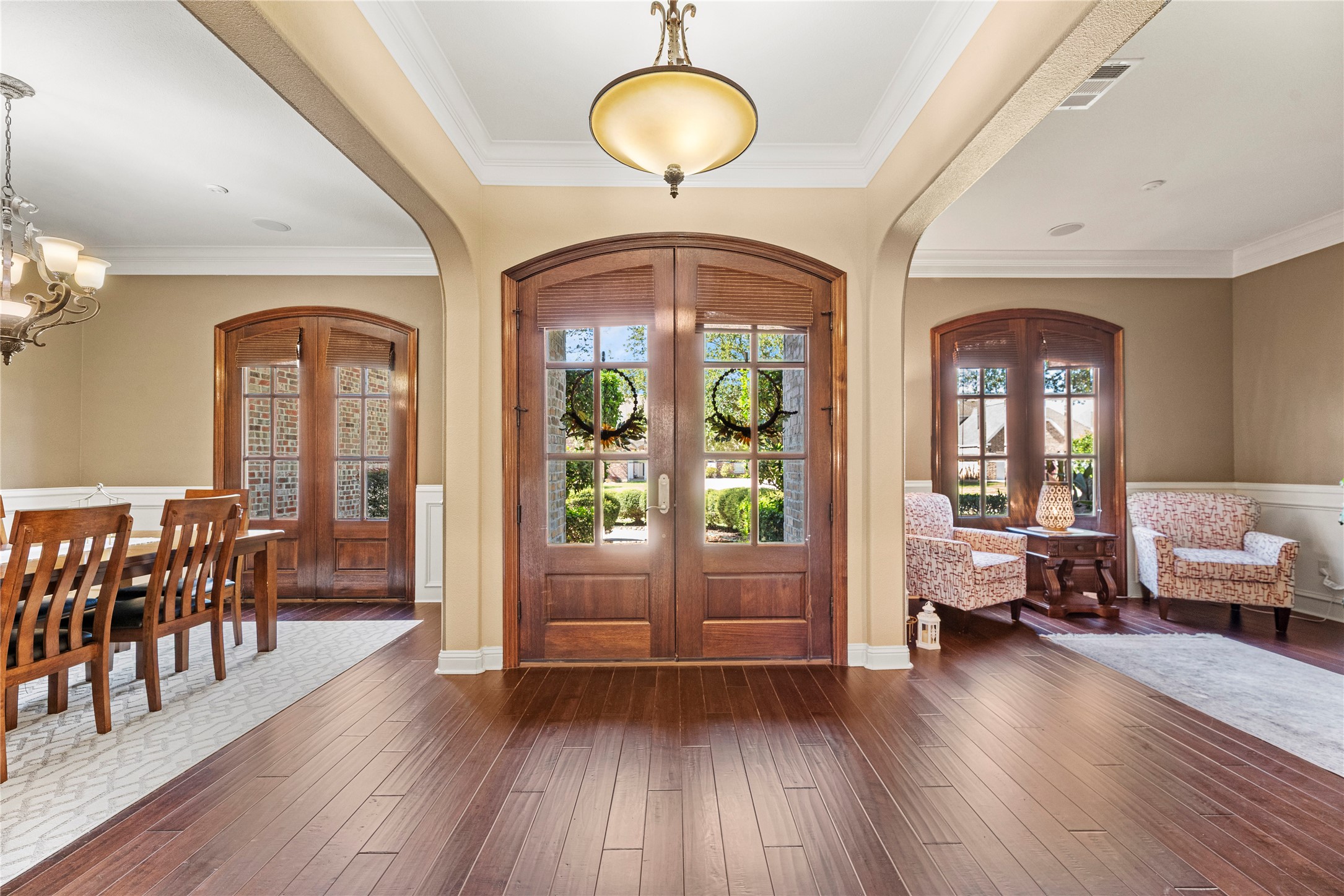3550 Windrose Drive Beaumont, TX 77706 - Photo 13 of 50 Spacious foyer framed by dual arched French doors, opening to the formal dining and front sitting rooms. Natural light pours through the tall windows highlighting classic millwork and crown molding.