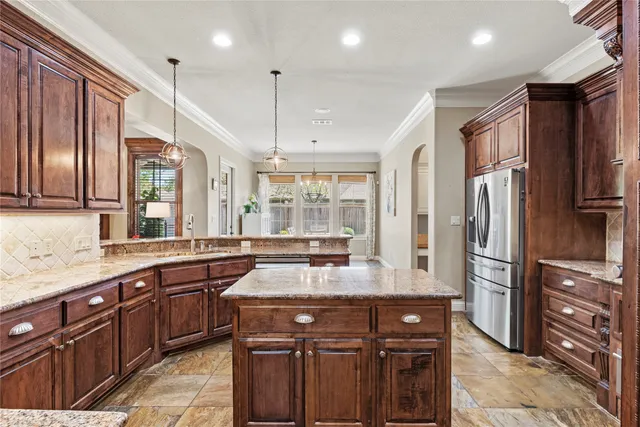 a kitchen with stainless steel appliances granite countertop a sink refrigerator and cabinets