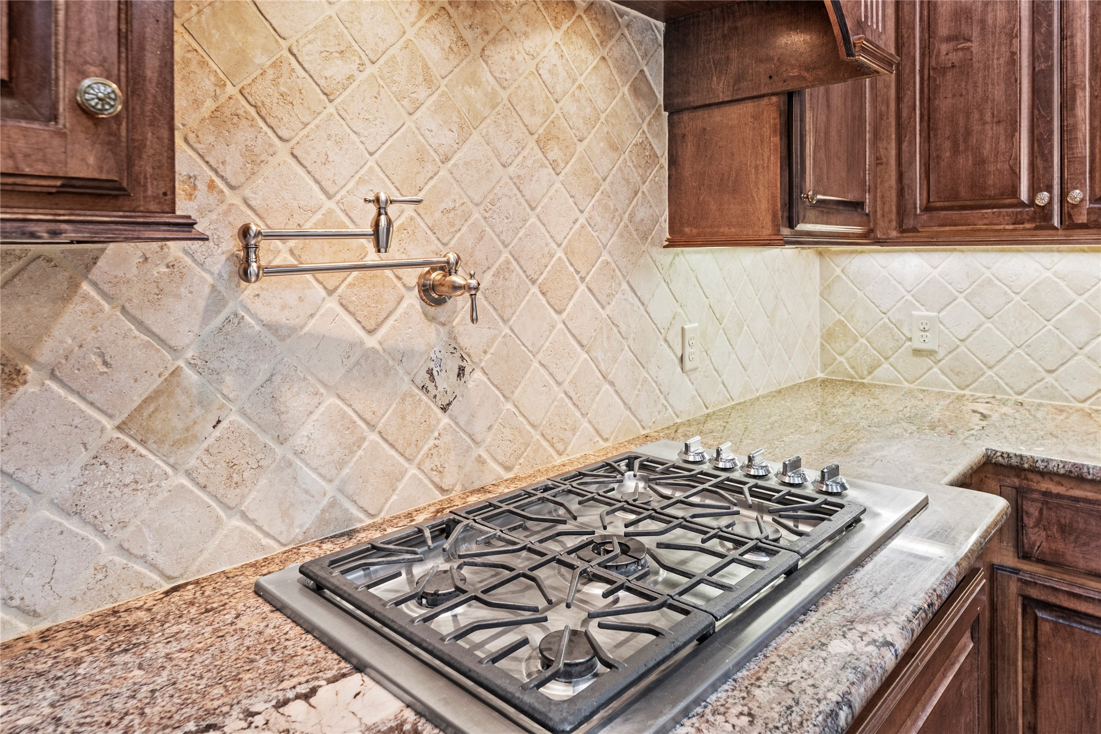 3550 Windrose Drive Beaumont, TX 77706 - Photo 21 of 50 Gourmet cooking station with five-burner gas cooktop, pot filler, and detailed wood range hood accented by carved corbels. Convenient pot-and-pan drawer plus a warming drawer add both luxury and practicality.