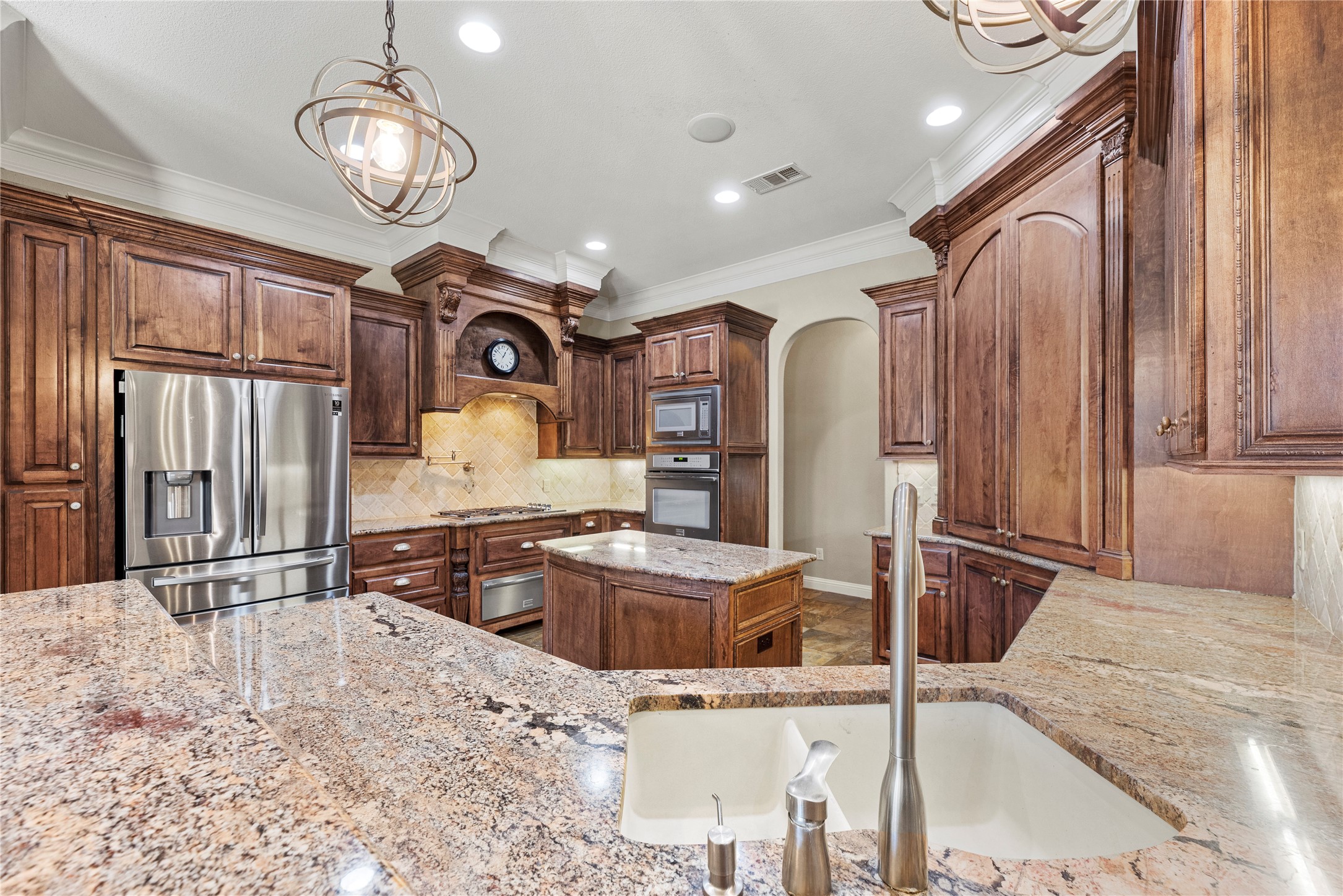 3550 Windrose Drive Beaumont, TX 77706 - Photo 22 of 50 mpressive chef’s kitchen with custom cabinetry, rich granite counters, and multicolor slate tile flooring. Elegant crown molding and pendant lighting complement the warm, classic design.