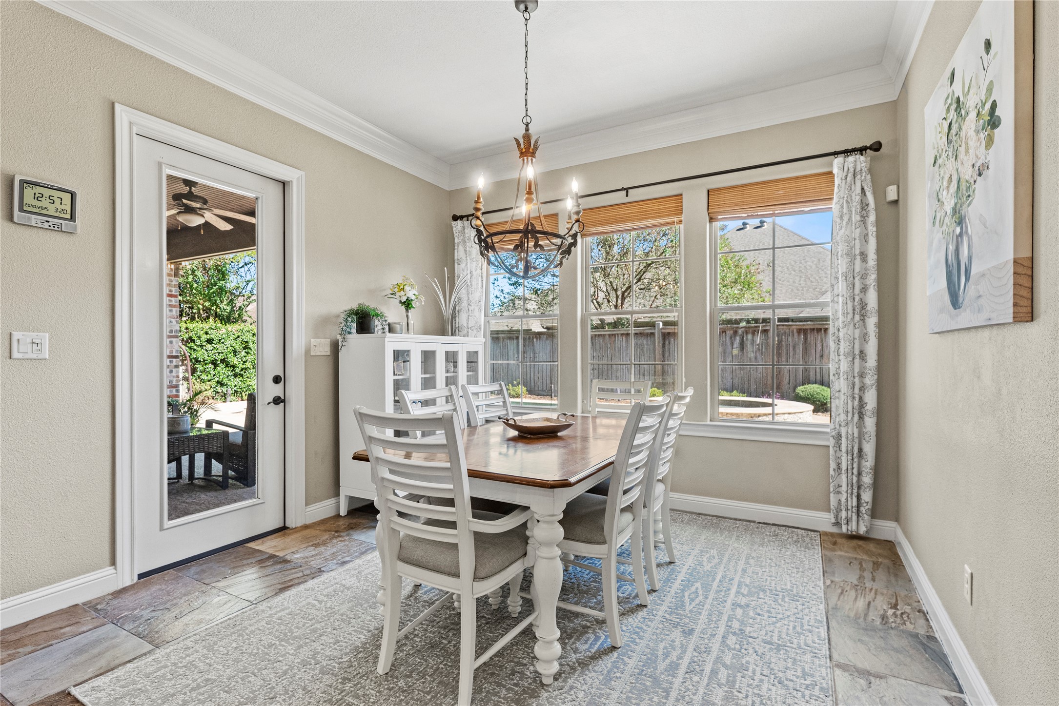 3550 Windrose Drive Beaumont, TX 77706 - Photo 24 of 50 Bright and inviting breakfast area surrounded by large picture windows overlooking the pool and backyard. Features crown molding, a warm chandelier, and rich multicolor slate tile flooring that flows seamlessly from the kitchen.