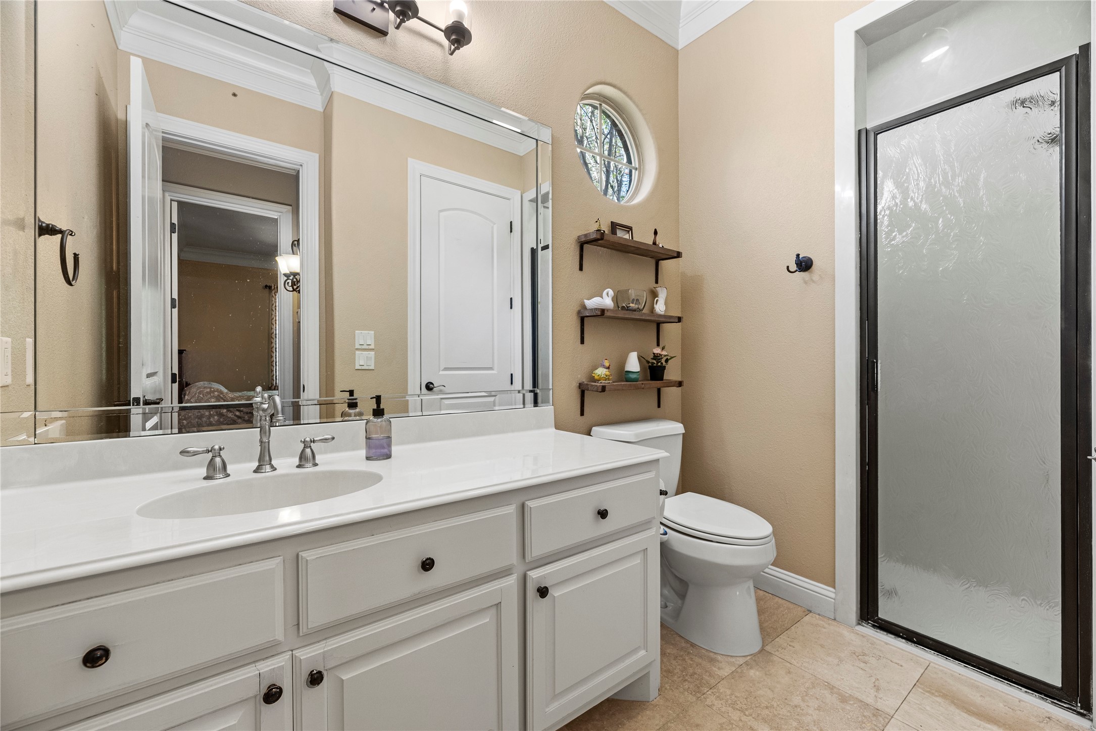 3550 Windrose Drive Beaumont, TX 77706 - Photo 32 of 50 Beautiful full bath with walk-in shower, framed mirror, and custom shelving. The neutral tones, crown molding, and quality finishes provide comfort and style for guests or family members alike.