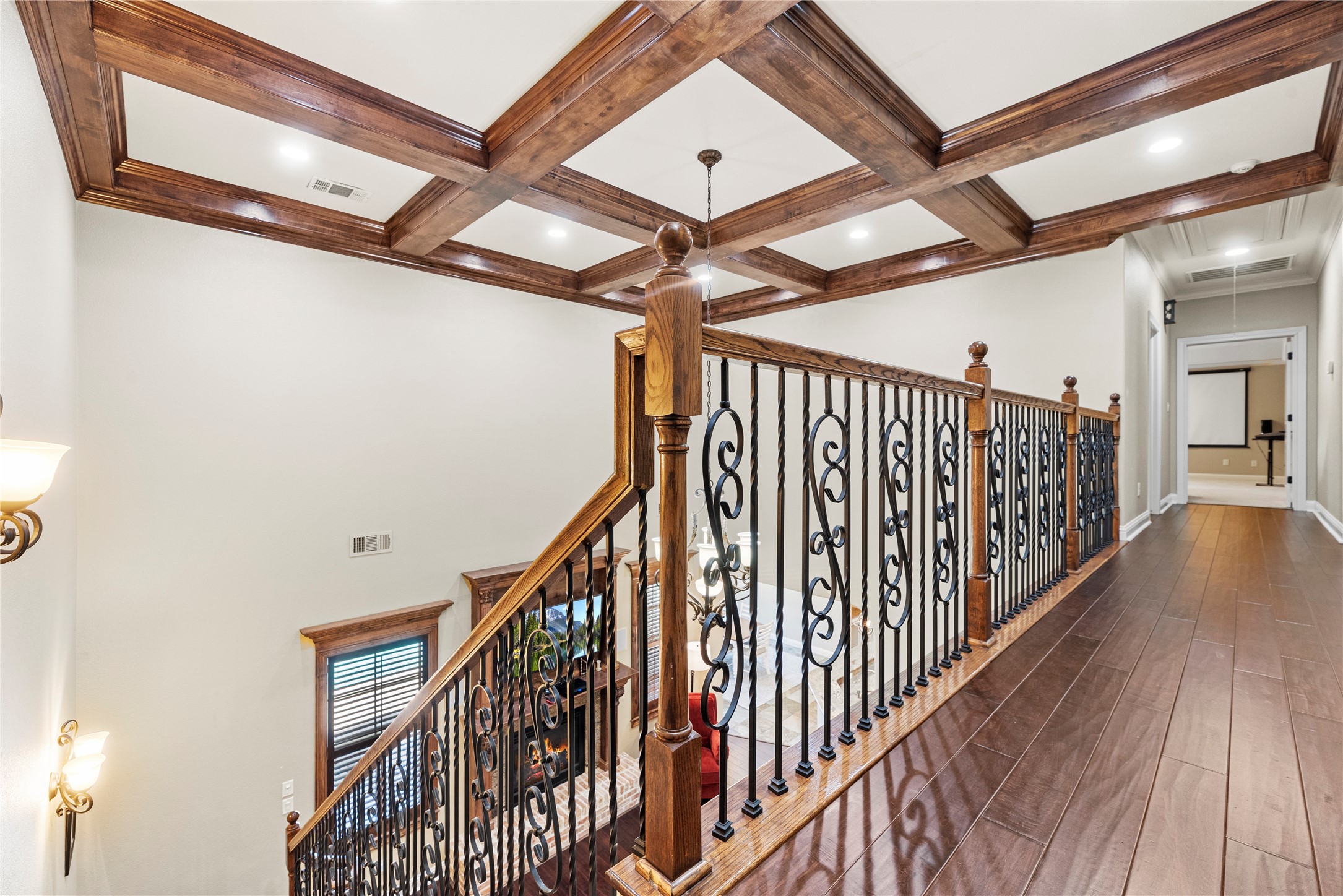 3550 Windrose Drive Beaumont, TX 77706 - Photo 35 of 50 Hand-crafted wrought-iron railing and stained wood accents continue upstairs, showcasing exceptional craftsmanship. The coffered ceiling detail adds architectural drama to the open hallway leading toward the media and game rooms and additional three bedrooms.
