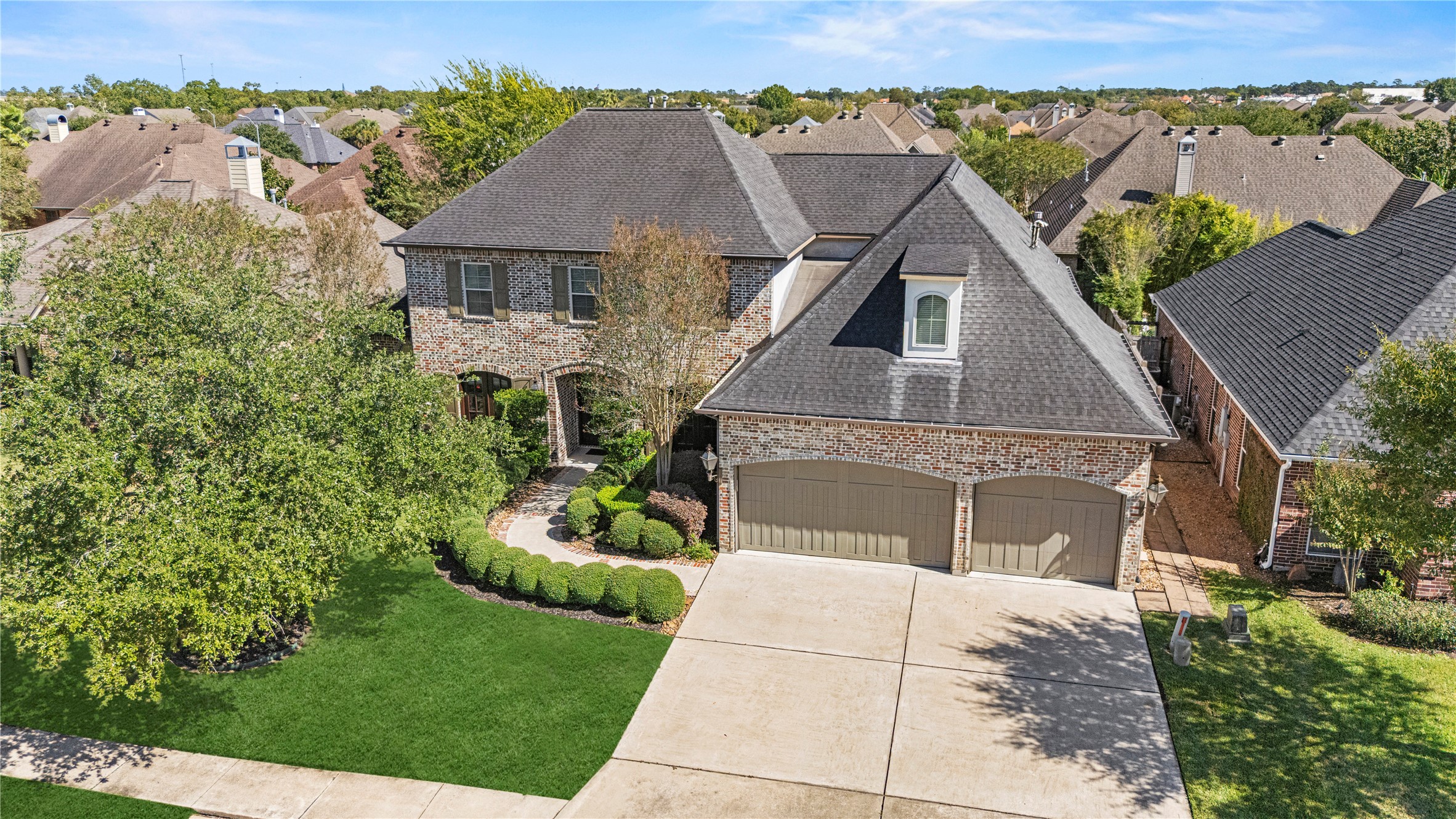 3550 Windrose Drive Beaumont, TX 77706 - Photo 45 of 50 Beautiful curb appeal from above — classic brick exterior, mature trees, and a wide driveway leading to a three-car garage.