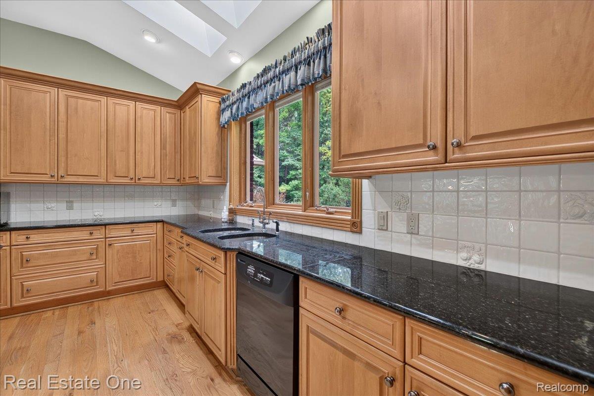 425 Courtney Road Leonard, MI 48367 - Photo 18 of 89 Kitchen featuring light wood cabinetry, dark speckled countertops, and a double basin sink
