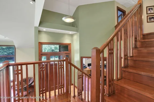 a view of staircase with lots of frames on wall and a large window