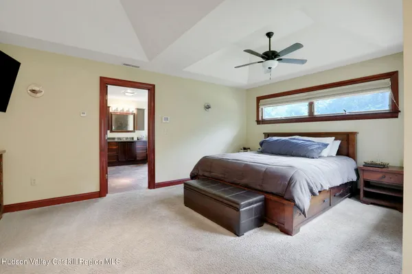 a spacious bedroom with a bed and a chandelier