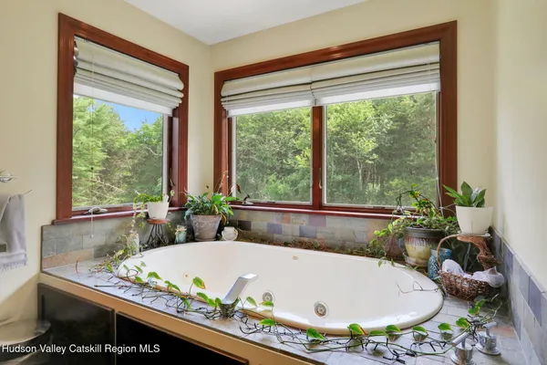 a white bath tub sitting in a bathroom next to a window