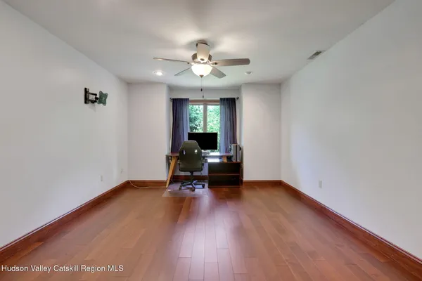a view of a room with wooden floor gym equipment and windows