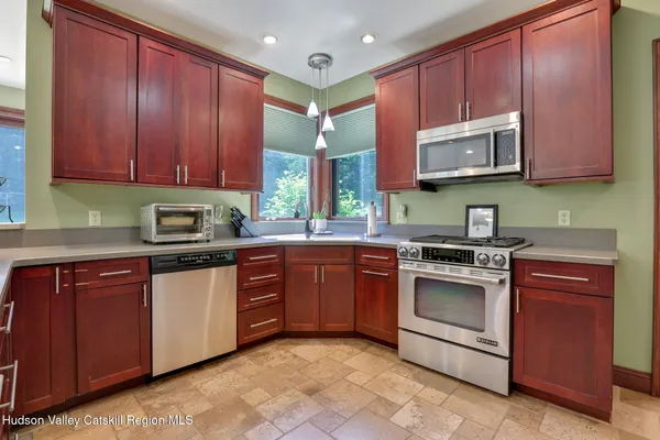 a kitchen with stainless steel appliances granite countertop wooden cabinets a stove top oven a sink and dishwasher