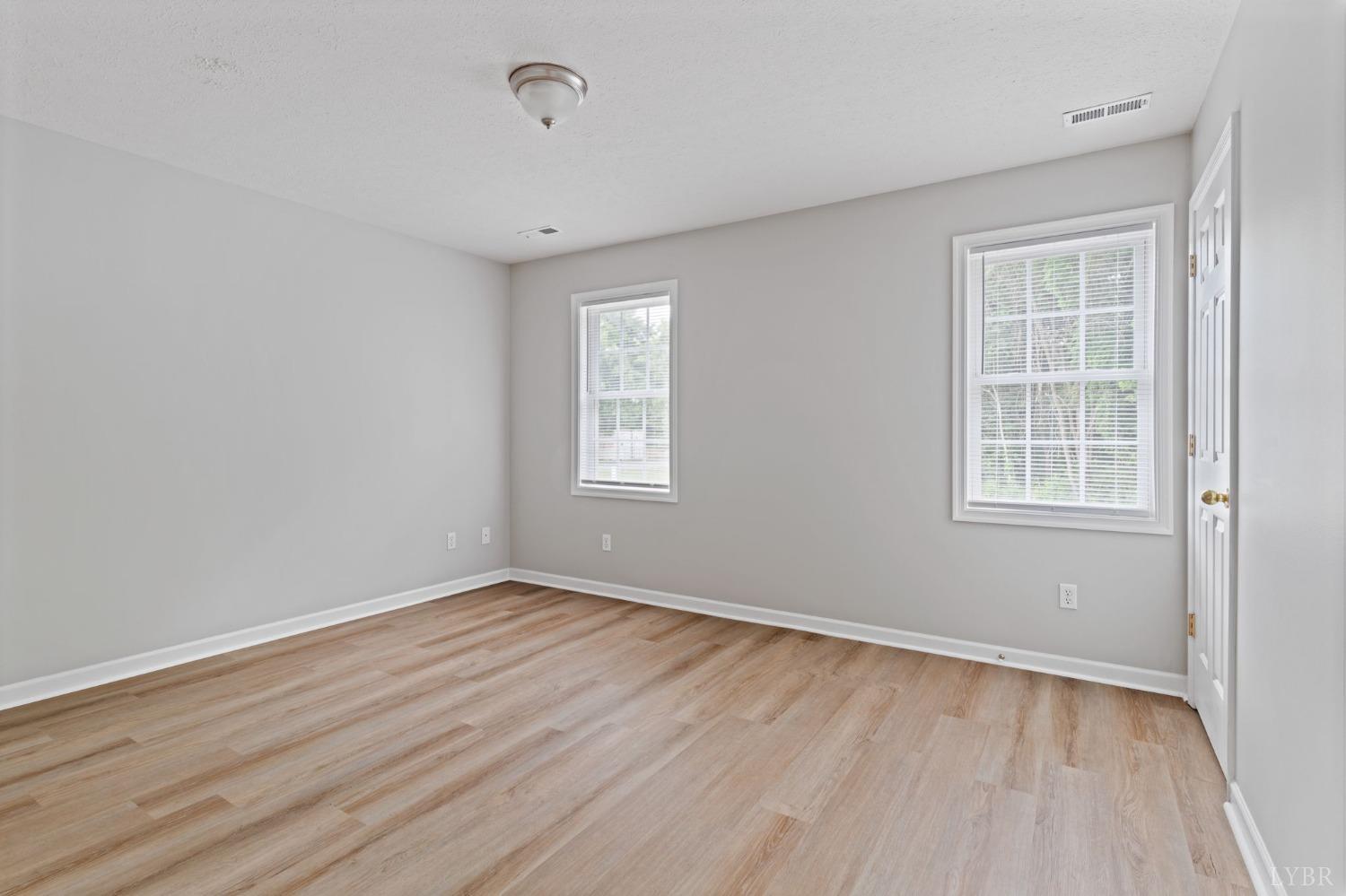 1083 Blane Drive Forest, VA 24551 - Photo 16 of 19 an empty room with wooden floor and windows
