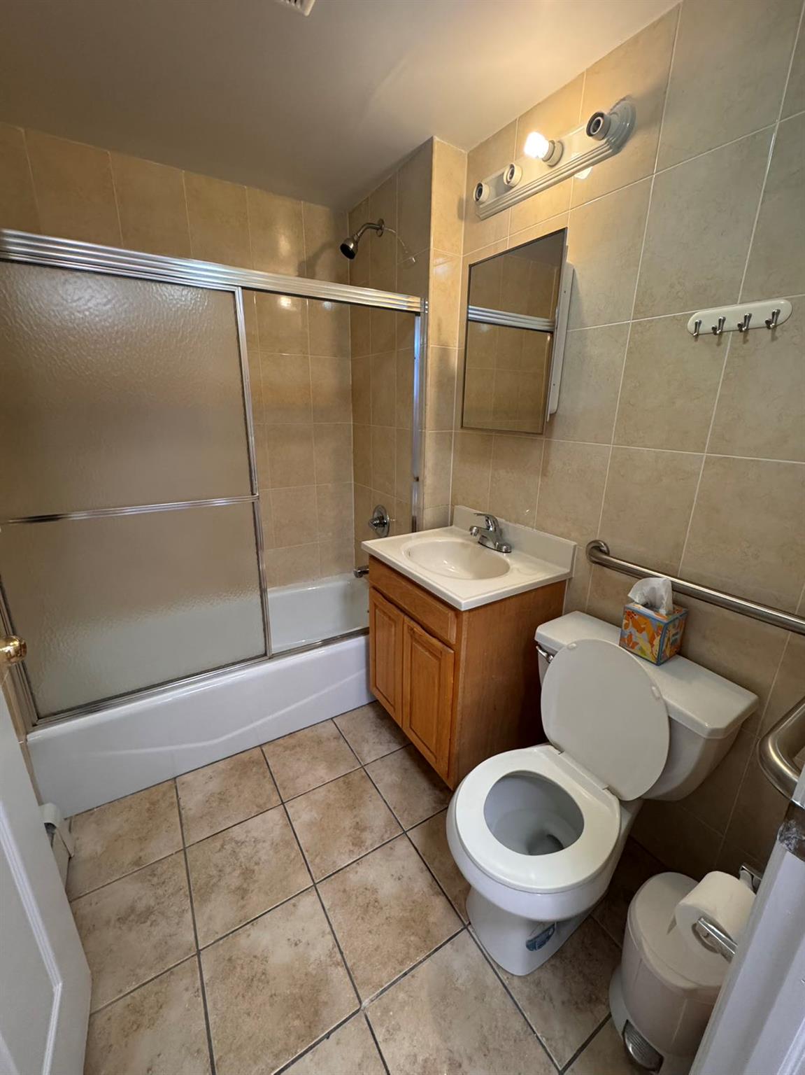 136-16 31st Road, Unit 8A Queens, NY 11354 - Photo 5 of 16 Full bathroom featuring vanity, tile patterned floors, tile walls, and enclosed tub / shower combo