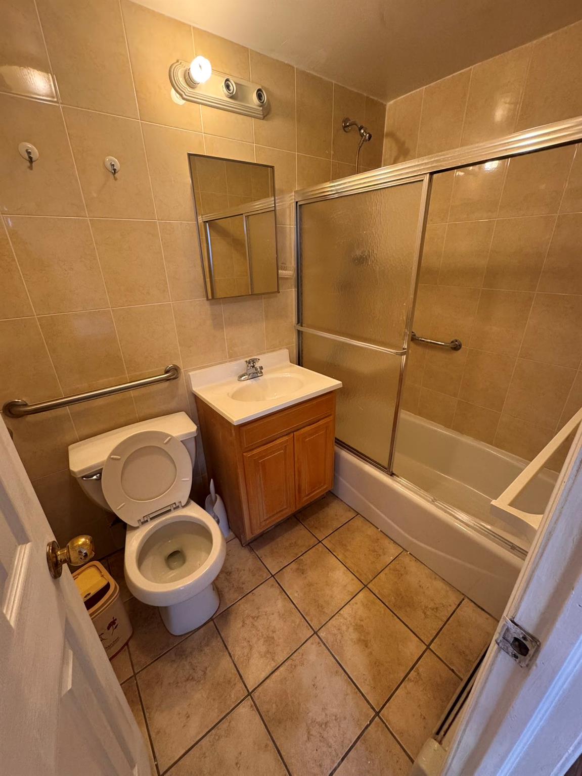 136-16 31st Road, Unit 8A Queens, NY 11354 - Photo 10 of 16 Full bathroom with tile patterned floors, bath / shower combo with glass door, vanity, tile walls, and toilet