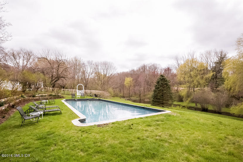 194 Bedford Road Greenwich, CT 06831 - Photo 28 of 44 a view of a swimming pool and trees in the background