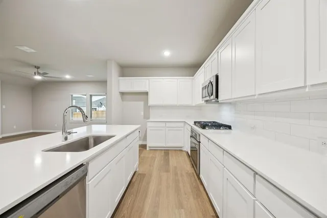 a kitchen with a sink stove and cabinets