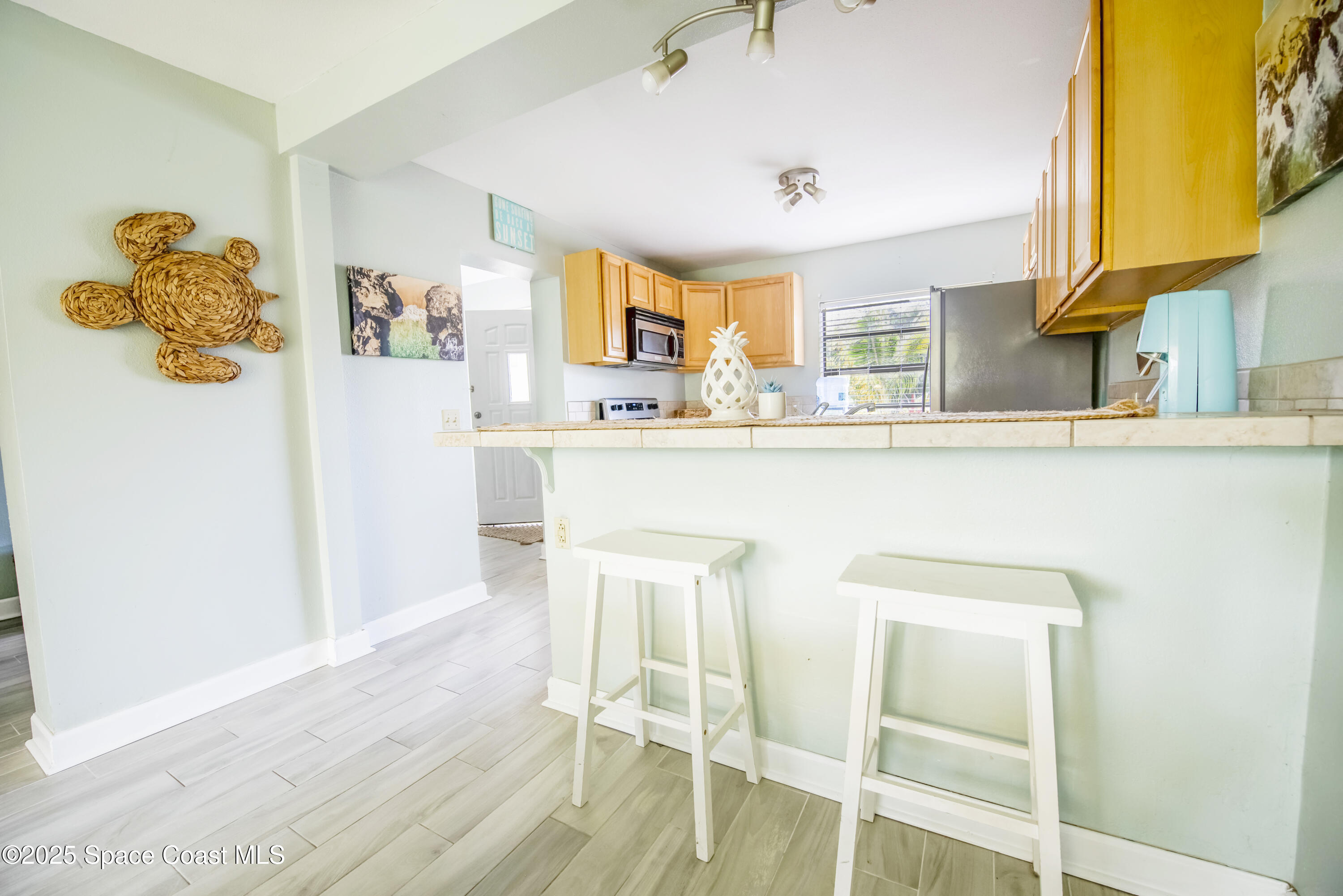 142 Atlantic Avenue Indialantic, FL 32903 - Photo 13 of 28 a kitchen with stainless steel appliances granite countertop a refrigerator and a wooden floor