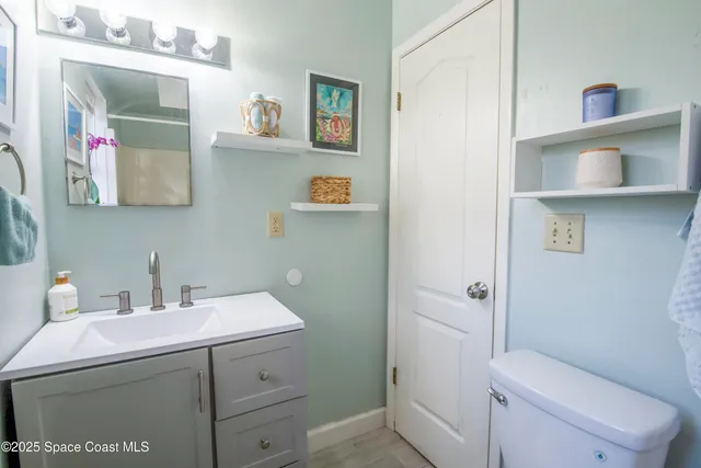 a bathroom with a sink mirror toilet and vanity