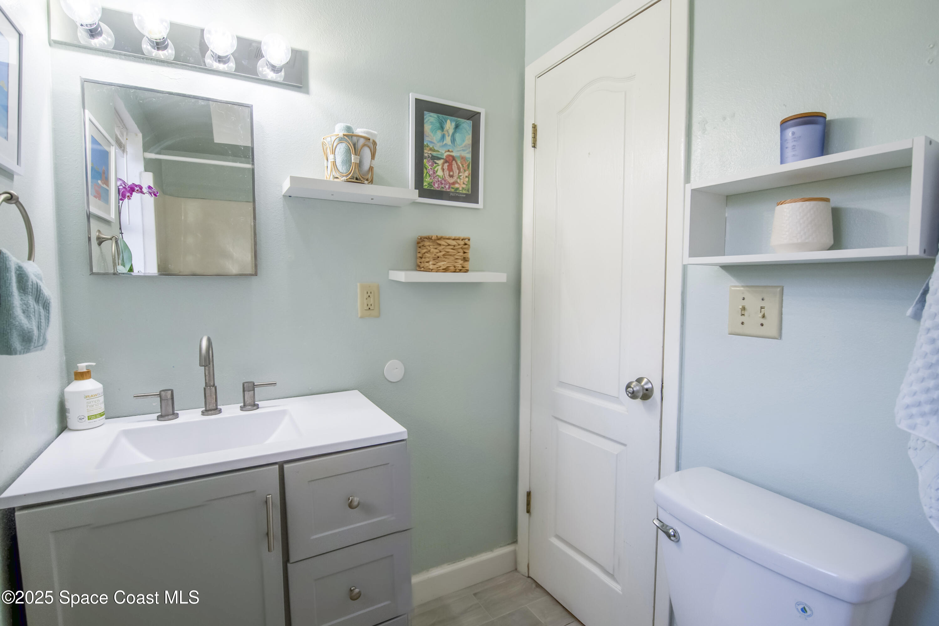 142 Atlantic Avenue Indialantic, FL 32903 - Photo 18 of 28 a bathroom with a sink mirror toilet and vanity