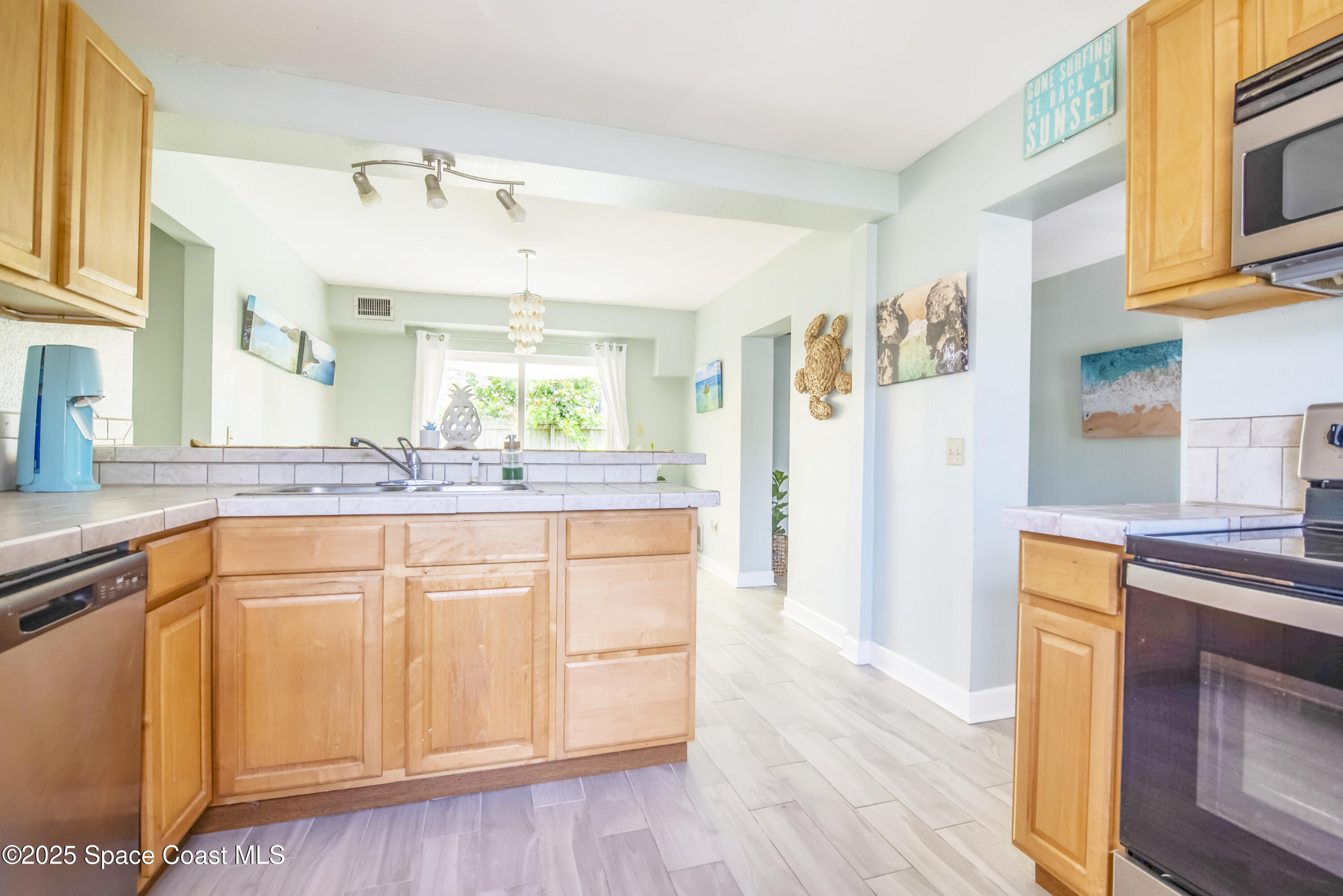 142 Atlantic Avenue Indialantic, FL 32903 - Photo 10 of 28 a kitchen with stainless steel appliances granite countertop a refrigerator a sink dishwasher and white cabinets with wooden floor