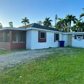 a front view of house with yard and potted plants