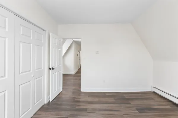 a view of an empty room with wooden floor