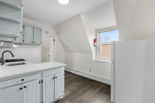 a room with a sink cabinets and wooden floor