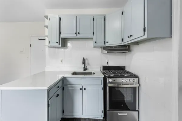 a kitchen with stainless steel appliances granite countertop a sink a stove and cabinets