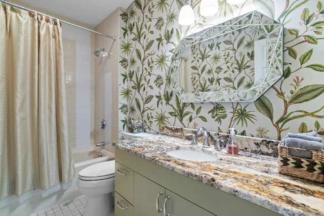 a bathroom with a granite countertop sink and a toilet