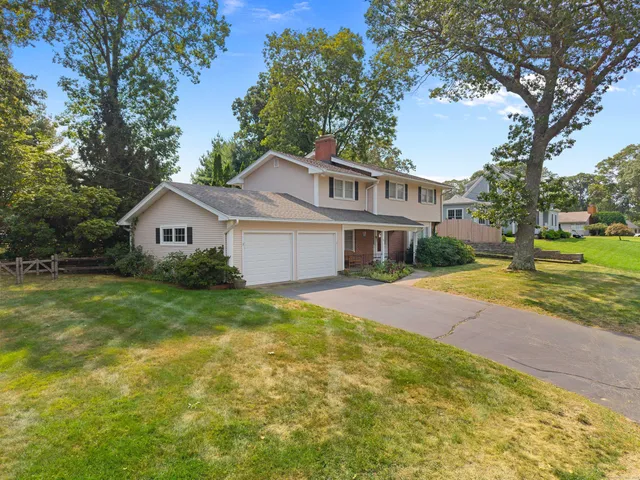 a front view of a house with a yard and trees