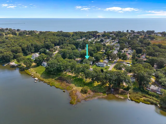 an aerial view of a houses with a yard and lake view