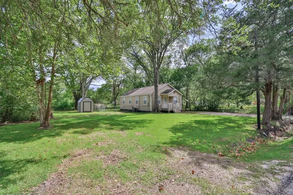 a backyard of a house with plants and large trees