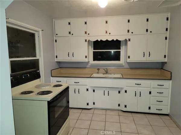 a kitchen with granite countertop white cabinets and black appliances