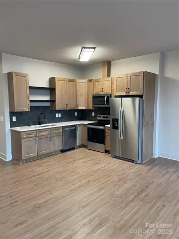 a view of kitchen with stainless steel appliances granite countertop a stove and a sink
