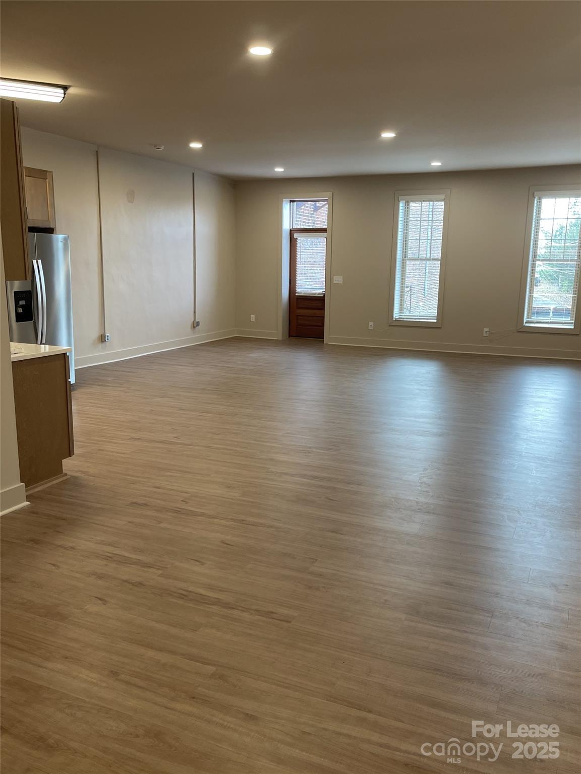 233 West Main Street, Unit B Albemarle, NC 28001 - Photo 5 of 12 an empty room with wooden floor and windows