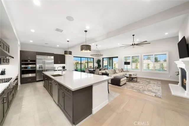 a kitchen with stainless steel appliances a dining table chairs and white cabinets