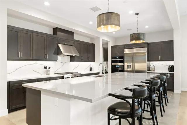 a large kitchen with stainless steel appliances kitchen island a large counter tops and a view of living room
