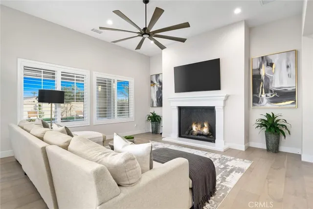 a living room with furniture a chandelier and a dining table
