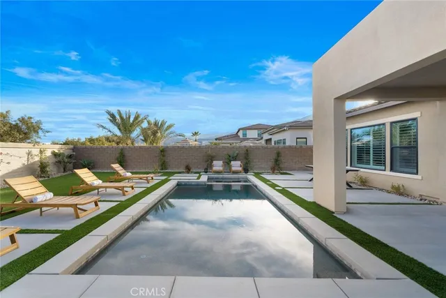 a view of a house with swimming pool and sitting area